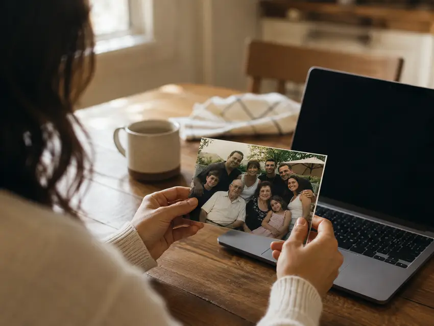 Choosing a family photo for the cookbook cover at a laptop